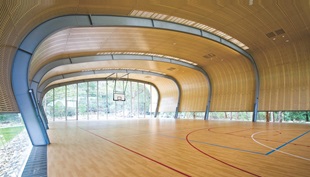 The structural steel bracing is integrated with the upturned hull-like roof, which is clad with LYSAGHT CUSTOM ORB® profile made from COLORBOND® Ultra Steel in the colour Dune®.