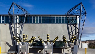 The roof made from COLORBOND® steel is suspended below the curving roof trusses, which reduced the external wall area by about 900m2 to achieve significant cost savings.