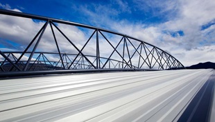 The roof made from COLORBOND® steel is suspended below the curving roof trusses, which reduced the external wall area by about 900m2 to achieve significant cost savings.