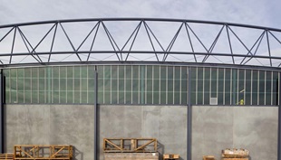 The roof made from COLORBOND® steel is suspended below the curving roof trusses, which reduced the external wall area by about 900m2 to achieve significant cost savings.